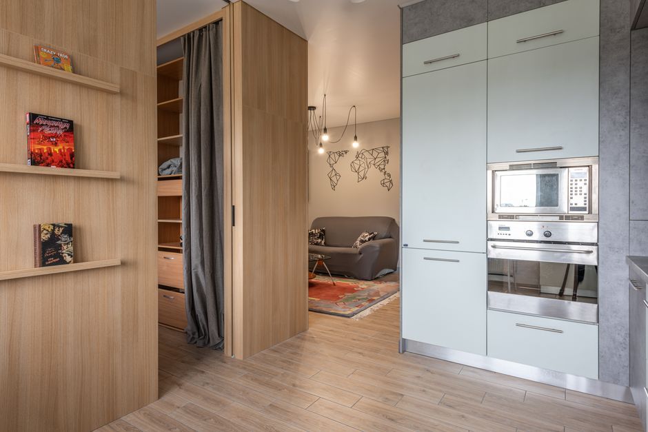 Appartement optimisé avec des placards intégrés et des étagères en bois près de l'entrée