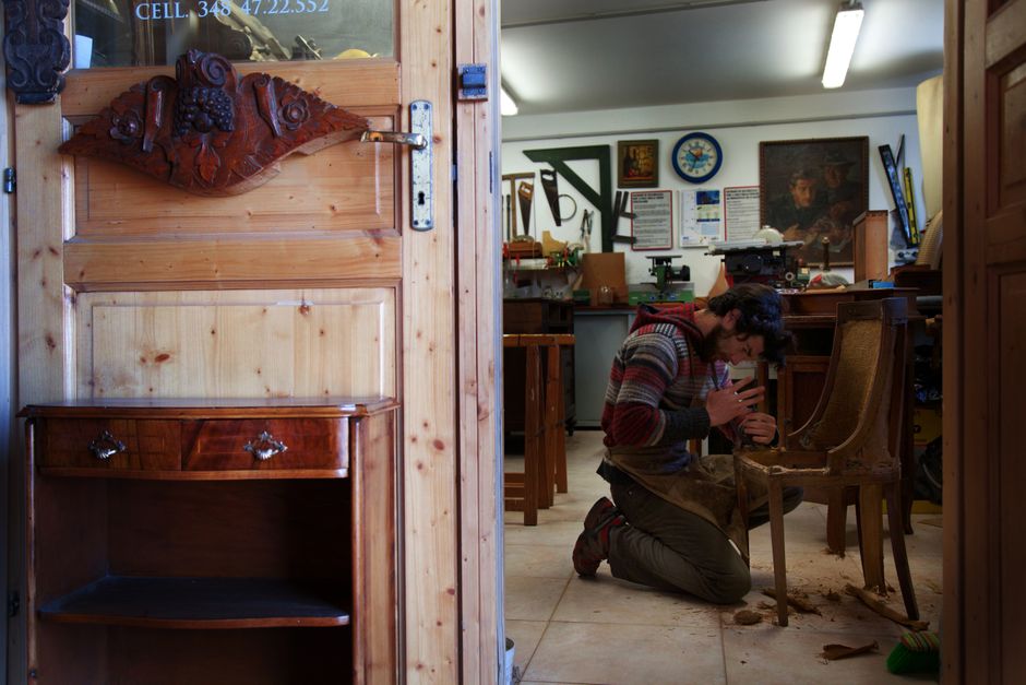 Artisan restaurant une chaise ancienne en bois dans son atelier
