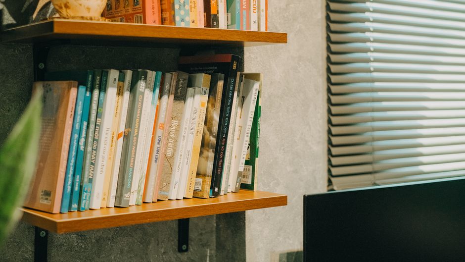 Livres rangés sur une étagère en bois dans un intérieur lumineux