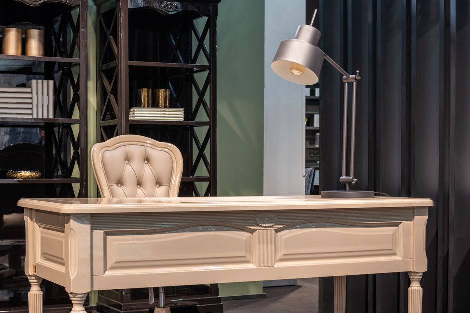 Bureau en bois avec lampe et étagères de livres dans un espace de travail