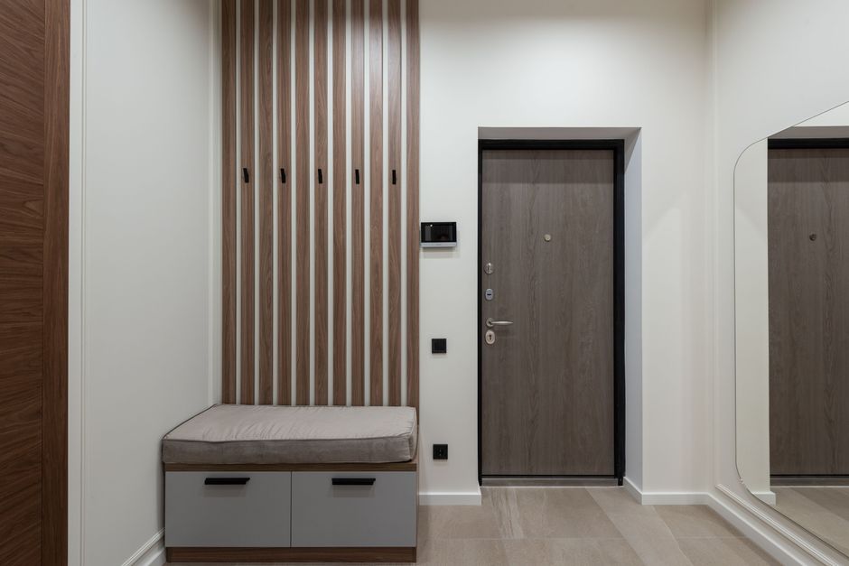 Entrée moderne avec un meuble de rangement en bois et un grand miroir