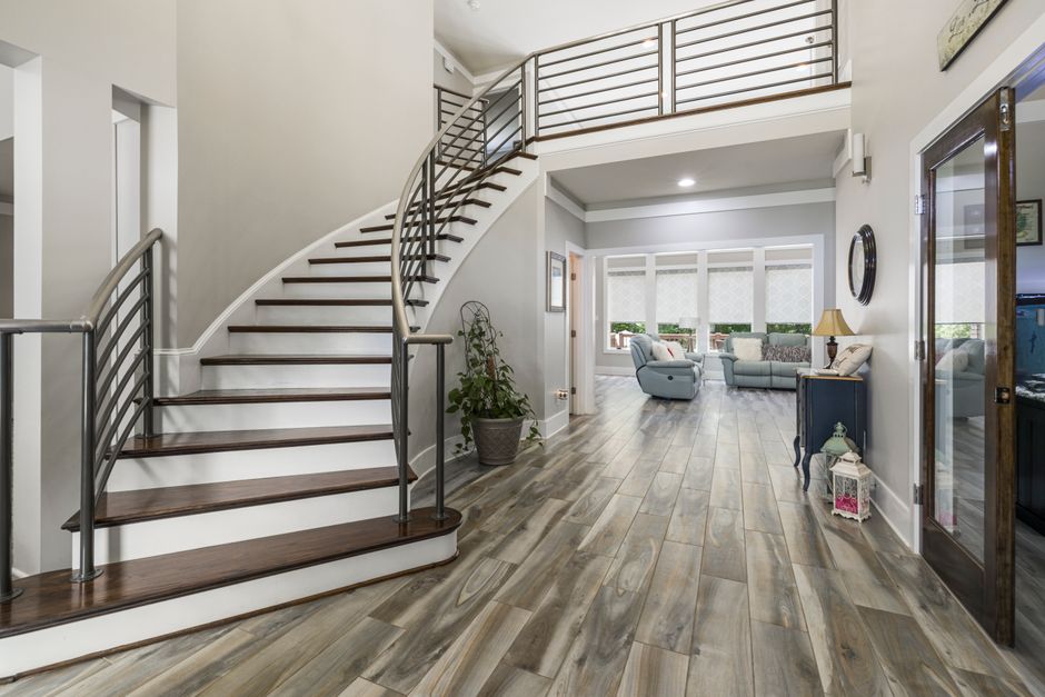 Escalier courbe en bois avec main courante métallique dans une maison moderne