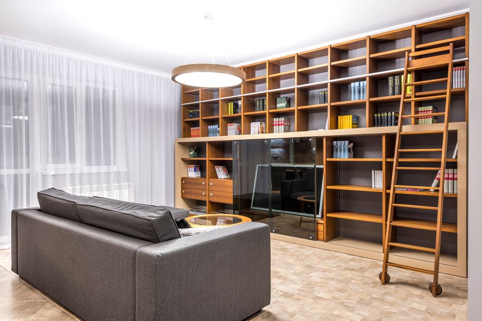 Grande bibliothèque en bois avec échelle dans un salon aux décors modernes
