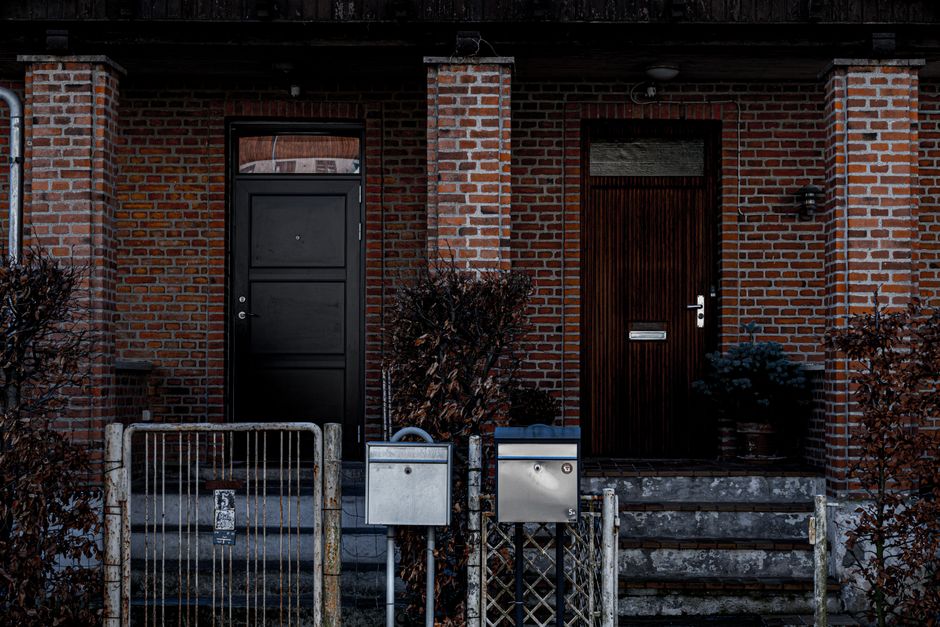 Porte d'entrée en bois sombre sur une façade en briques